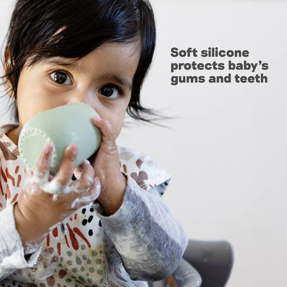 Child holding a green silicone baby teether with text about its benefits.
